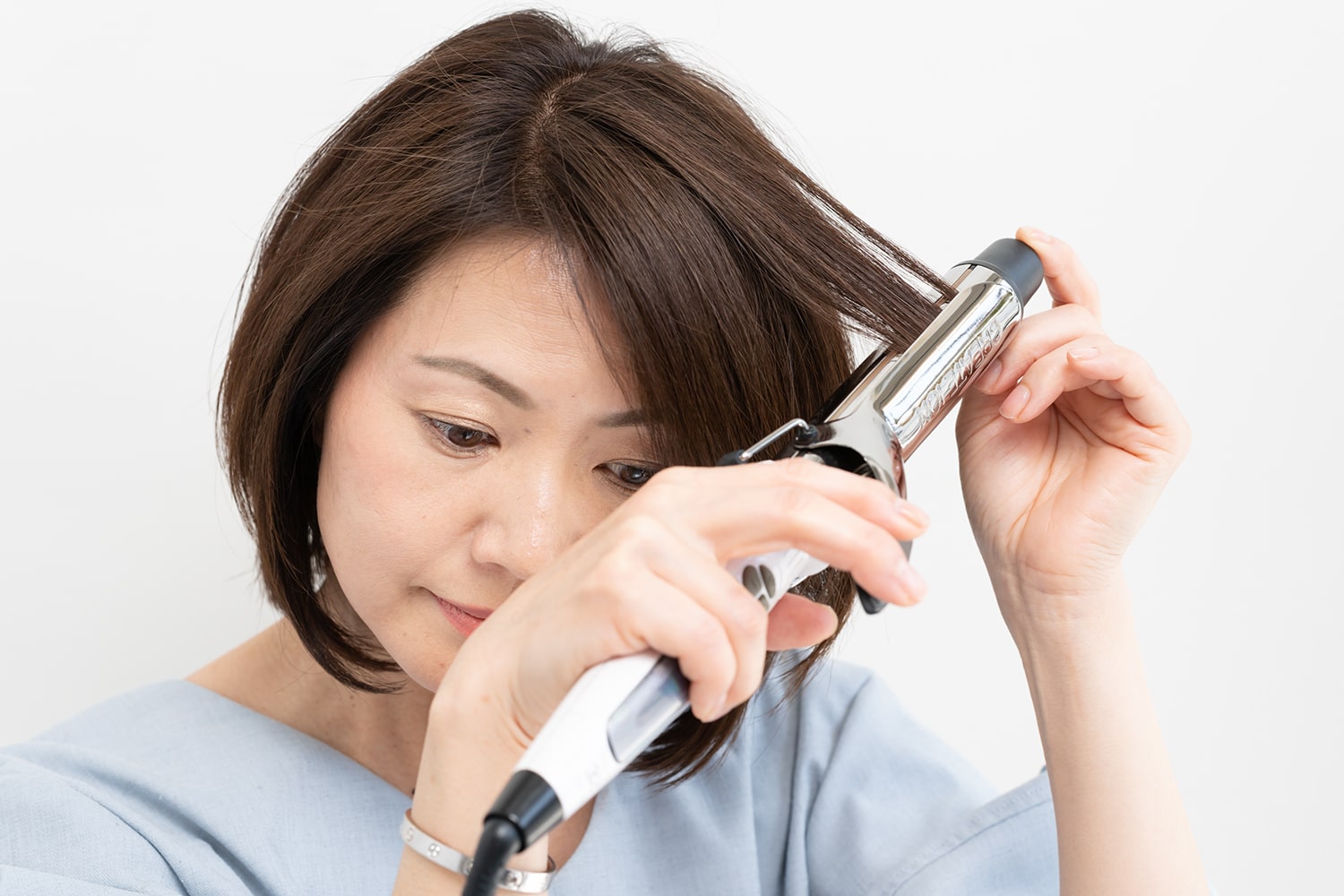 コテは32mmを使用。表面の髪の根元から毛先にかけてコテで熱を通す。コテでブローするようなイメージで。毛束は細かく取ると動きが出る。