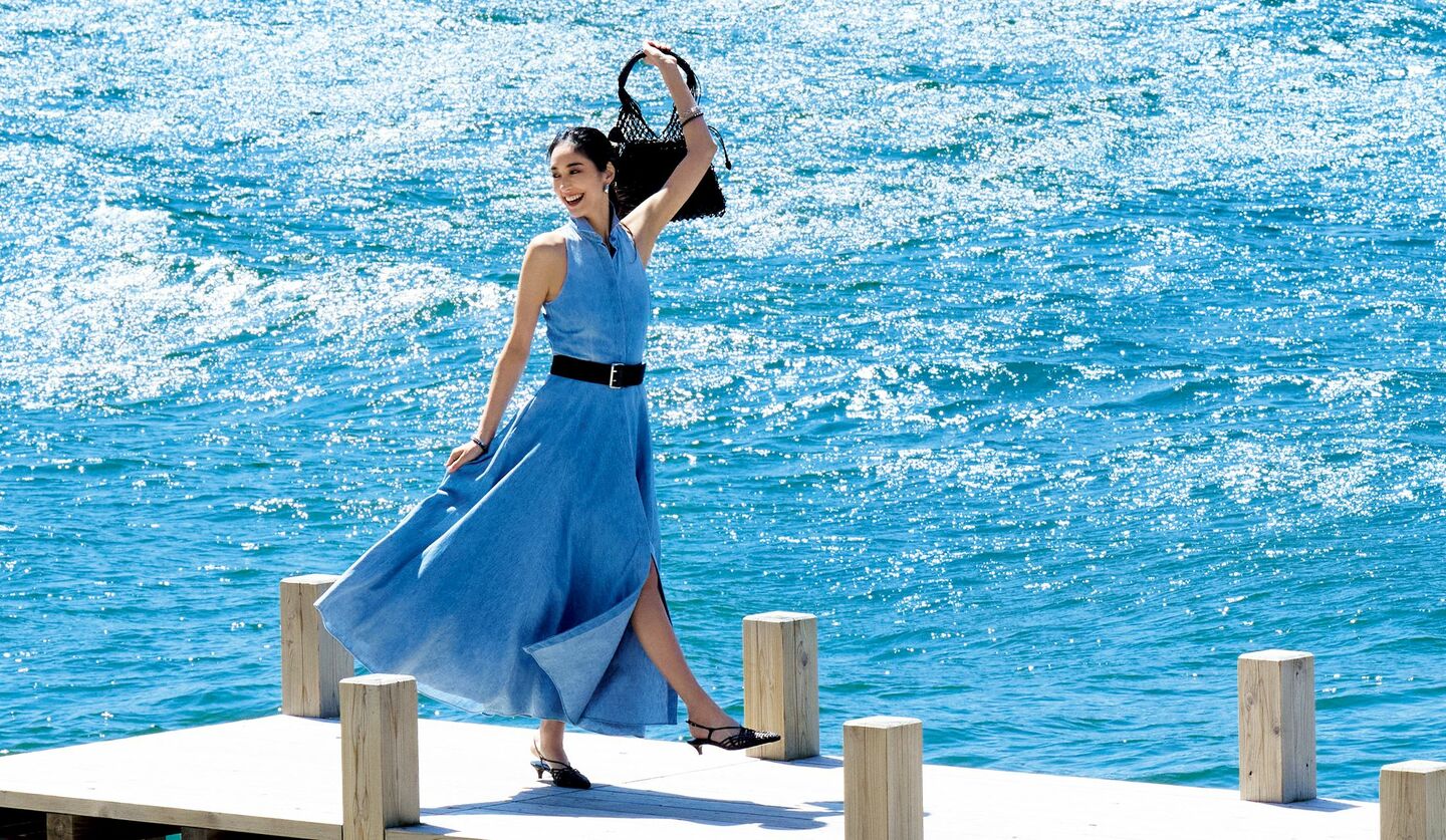 澄み渡る湖の景色に似合うラルフ ローレンのワンピースを着用した立野リカさん