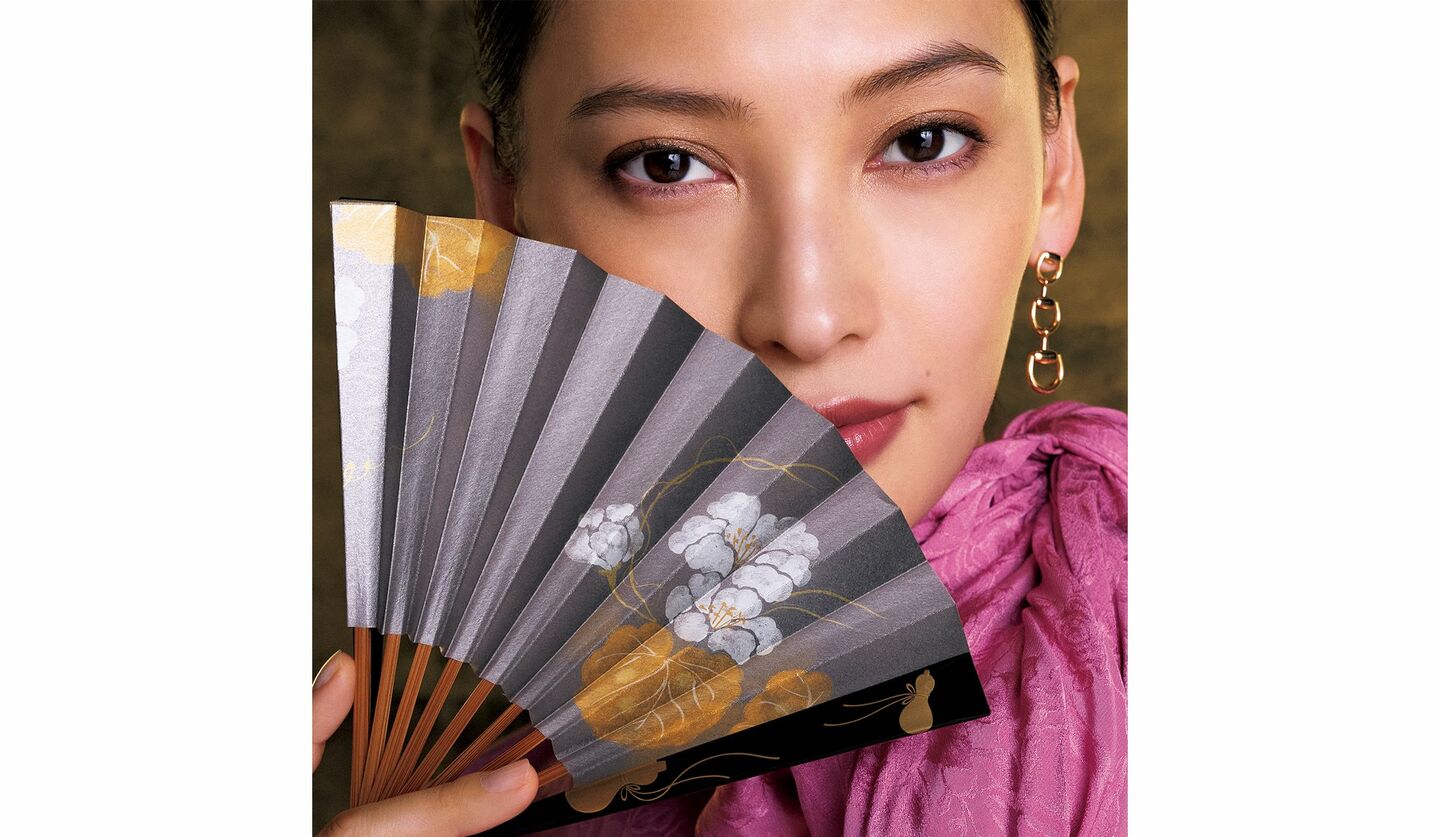 グッチのブラウスを着用し瓢箪の扇子を持った大政絢さん