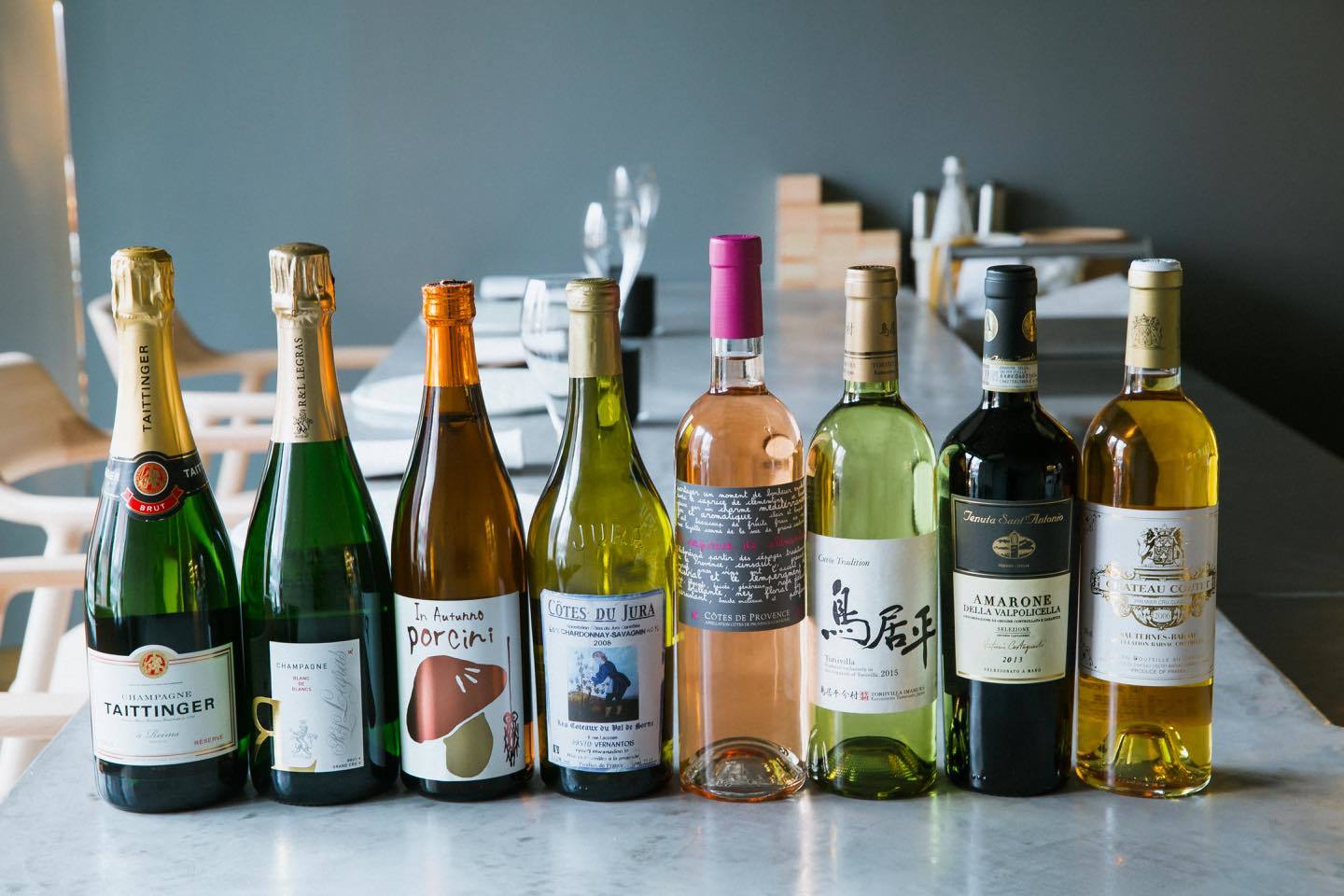 ワインペアリングはディナーが9杯¥9,000〜、ランチはお客様に合わせたグラス数で¥5,000〜。写真はディナーへのペアリング例。乾杯用とフィンガーフード向けにシャンパンを2種用意したり、ポルチーニのイラストが目を引く日本酒が登場したり、メインにあえてイタリアワインを合わせたりと、マネージャーの松本将尚さん曰く「ひと筋縄でいかないラインナップ」。ペアリング以外も注文可能で、ワインはグラス¥1,200〜(ランチ)、¥1,800(ディナー)、ボトル¥6,000〜。フランスの主なワイン産地に加え、イタリア、アメリカ、チリ、日本など世界各国からセレクト。