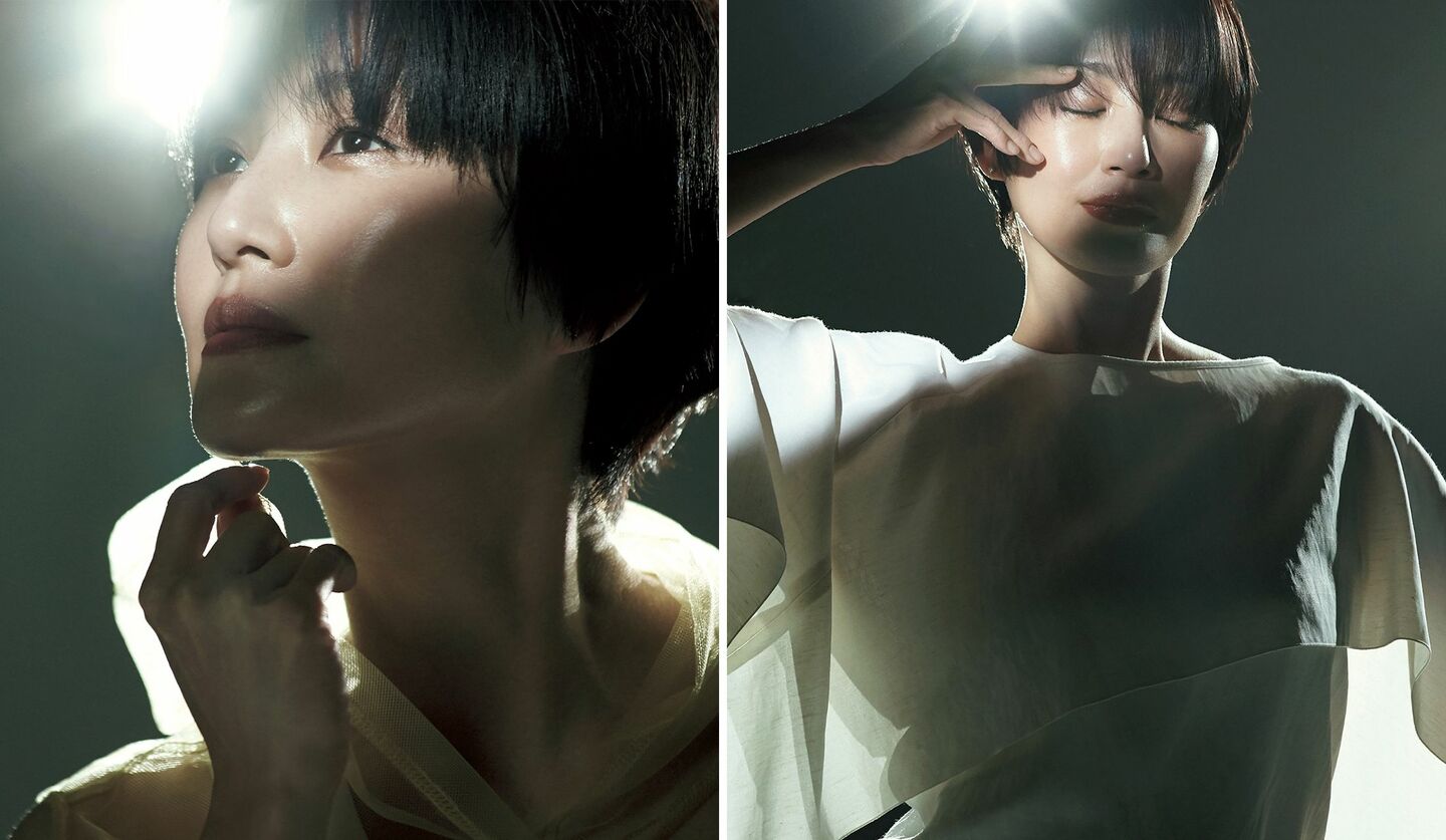 顔に手を当て、左から光が差し込んでいるモデルのバストアップ写真