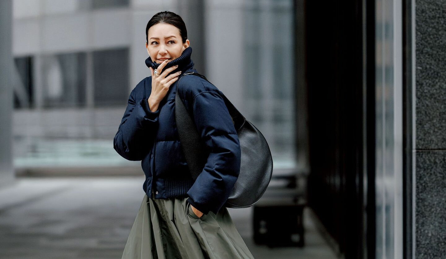 「theory」のダウンコートと「オブリオ」のロングスカートを着用したモデル