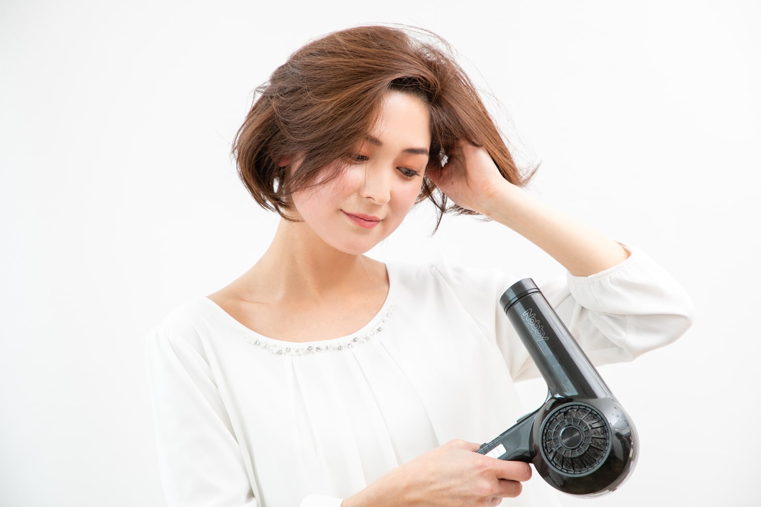 下から風を当て、髪の根元に空気を入れながら全体を乾かす。