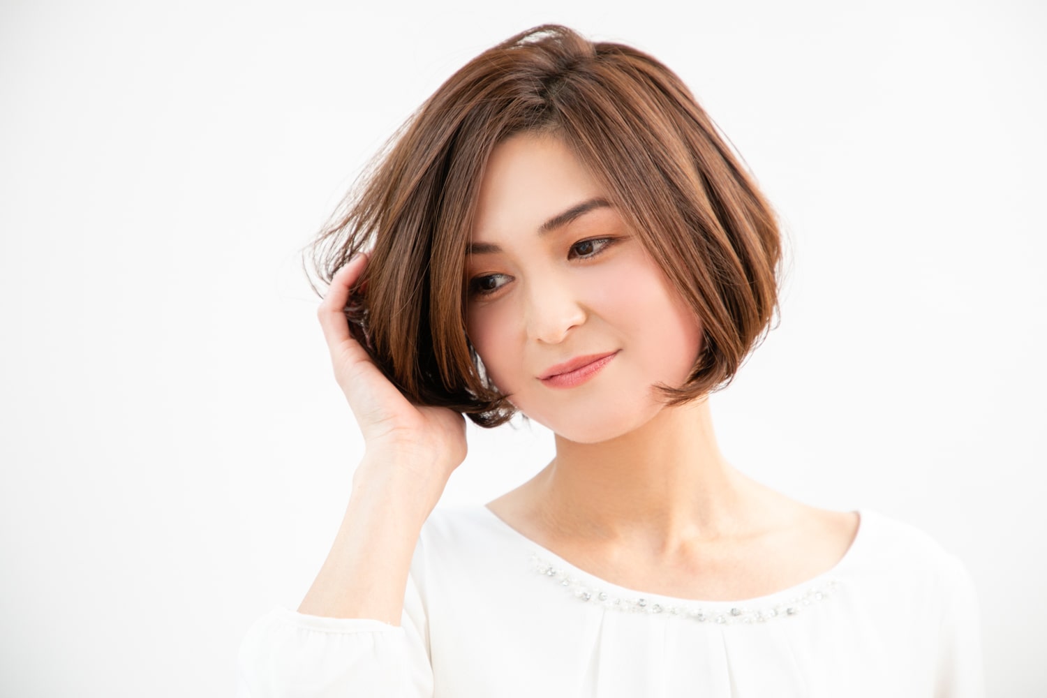 バームタイプのワックスを手にのばし、髪の内側に空気を入れながら全体に揉み込む。