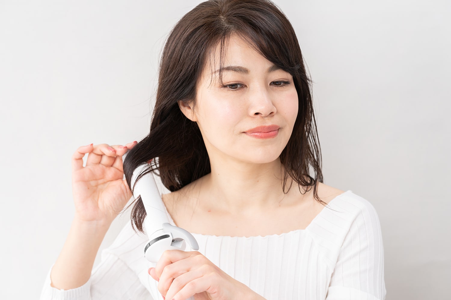 襟足の毛束を前に持ってきて中間を巻く。逆の襟足も同様もリバースすれば完成。