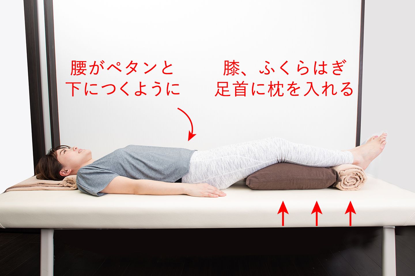 まくらとバスタオルで膝、ふくらはぎ、足首にまくらをいれている様子