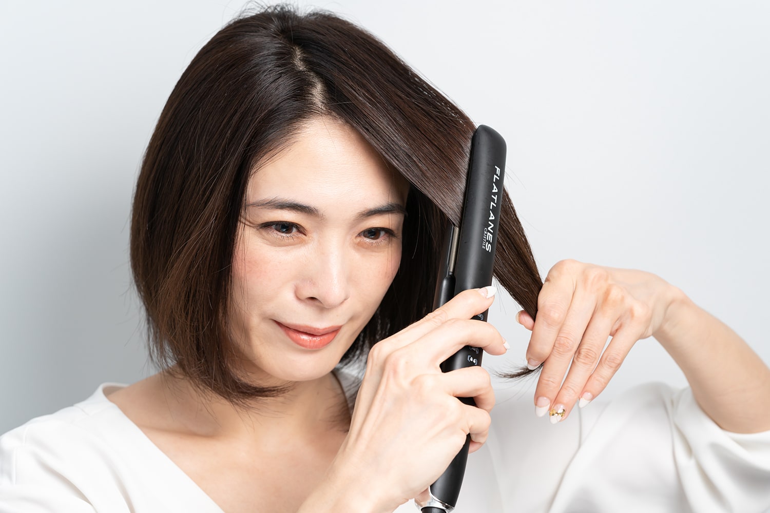 片方の手で毛束の先を軽く引っ張りながらアイロンを通すとツヤも出やすい。