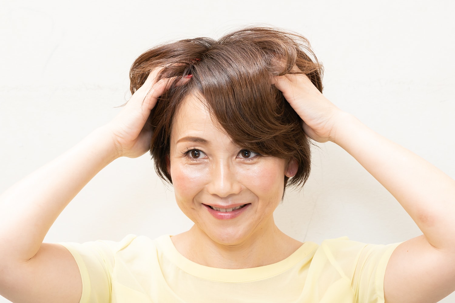 パールひと粒大のハードワックスを手のひらに薄く伸ばし、髪全体にしっかりともみ込む。表面ではなく、髪を握るように内側からもみ込むのがポイント。
