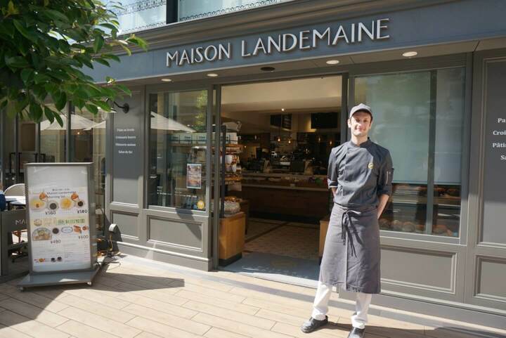 メゾン・ランドゥメンヌの店舗外観と、店の前に立つフランス人パン職人の写真