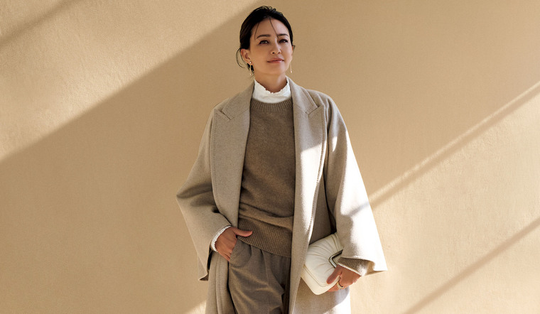 「マックスマーラ」のブラウス、ニット、パンツ、コートを着用したモデル