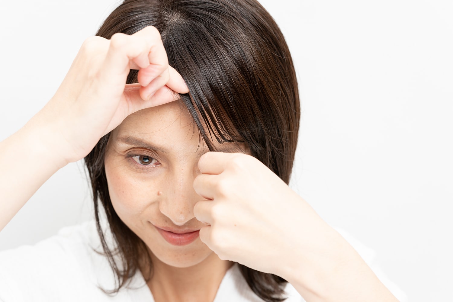 毛先になじませたオイルが残っている指先で、ひとつまみずつ毛束を毛先までつまんで。