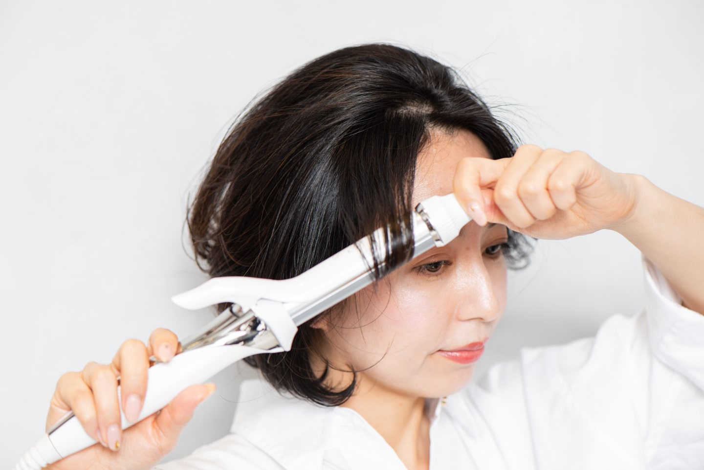 ハチ上の顔周りの髪は、前に引き出して、毛先から1回転半内巻きにする。