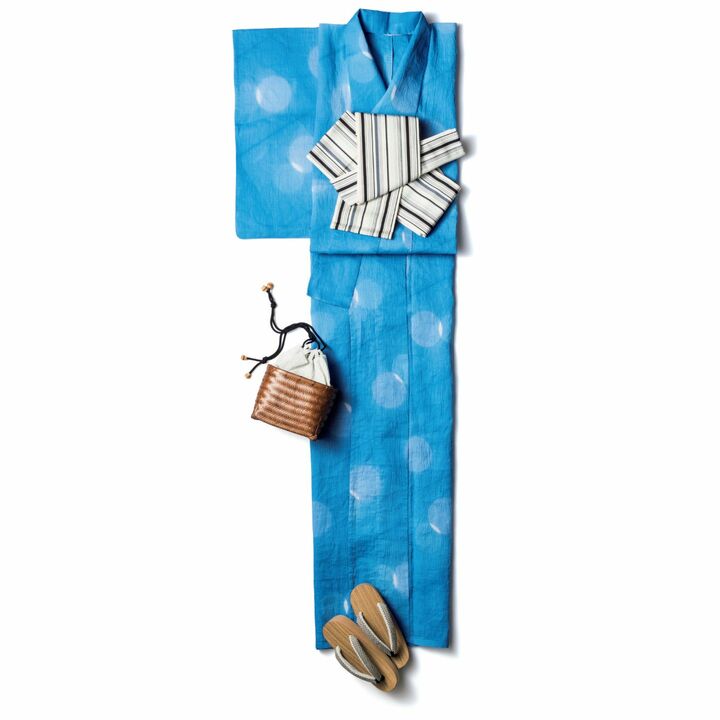 九州地方の伝統織物、博多織の半幅帯は、貝の口や矢の字という粋な帯結びで。上質素材の竹草履も大人の贅沢。綿麻の浴衣［仕立て上がり価格］¥100,000・博多織の半幅帯¥50,000・胡麻竹の草履¥30,000（田園調布 秀や）、巾着バッグ¥22,000（アタリー）