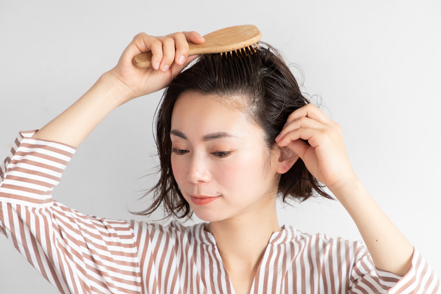 髪が濡れた状態で、頭皮用ブラシでオールバックにブラッシングし、根元を立ち上げる。