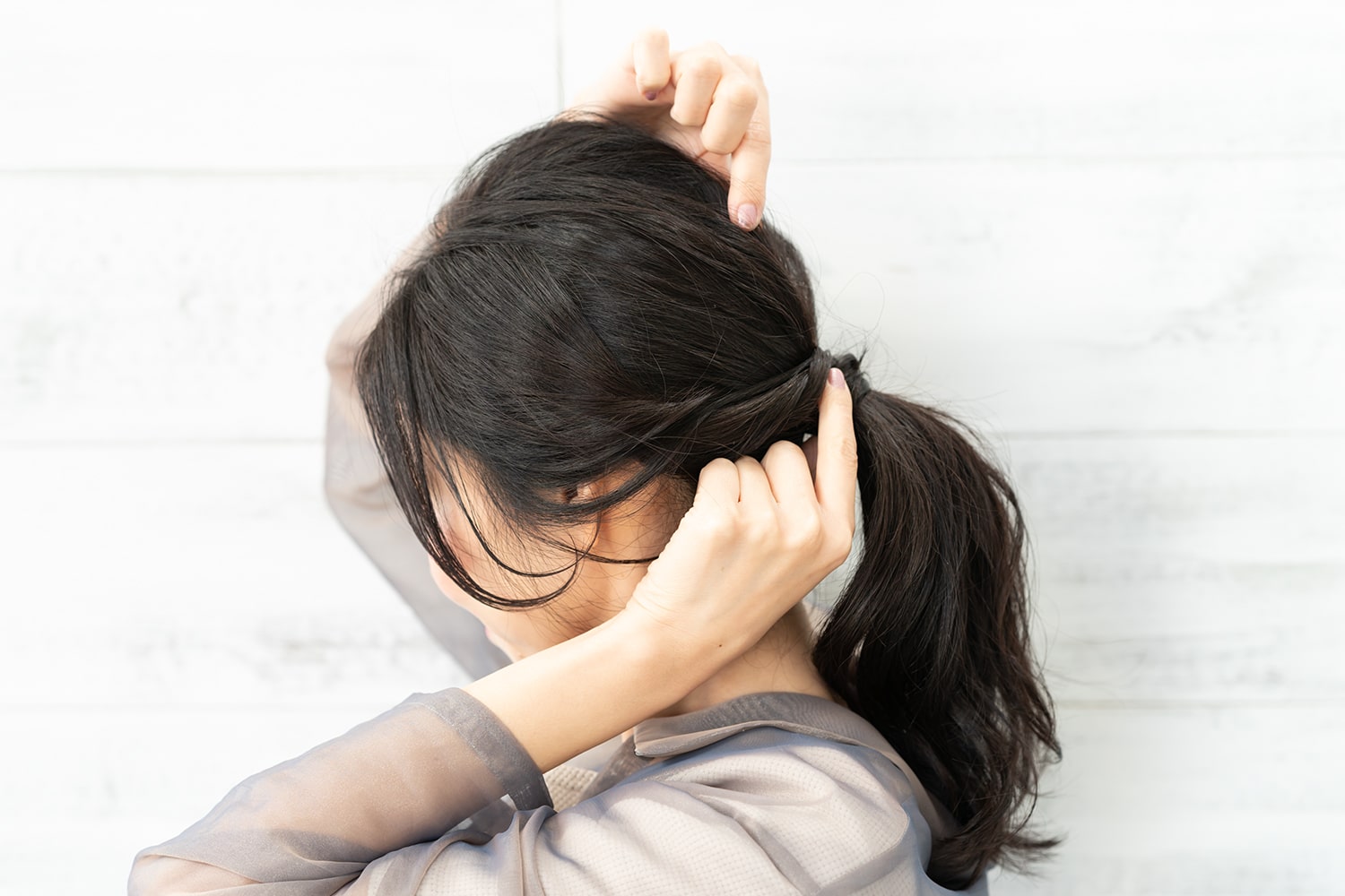 ゴム付近を持ちながら後頭部の髪を引き出す。高さを出したいので、しっかりと引き出してOK。ボリューム感が足りないときは、引き出した両隣の毛束も同様に引き出して。