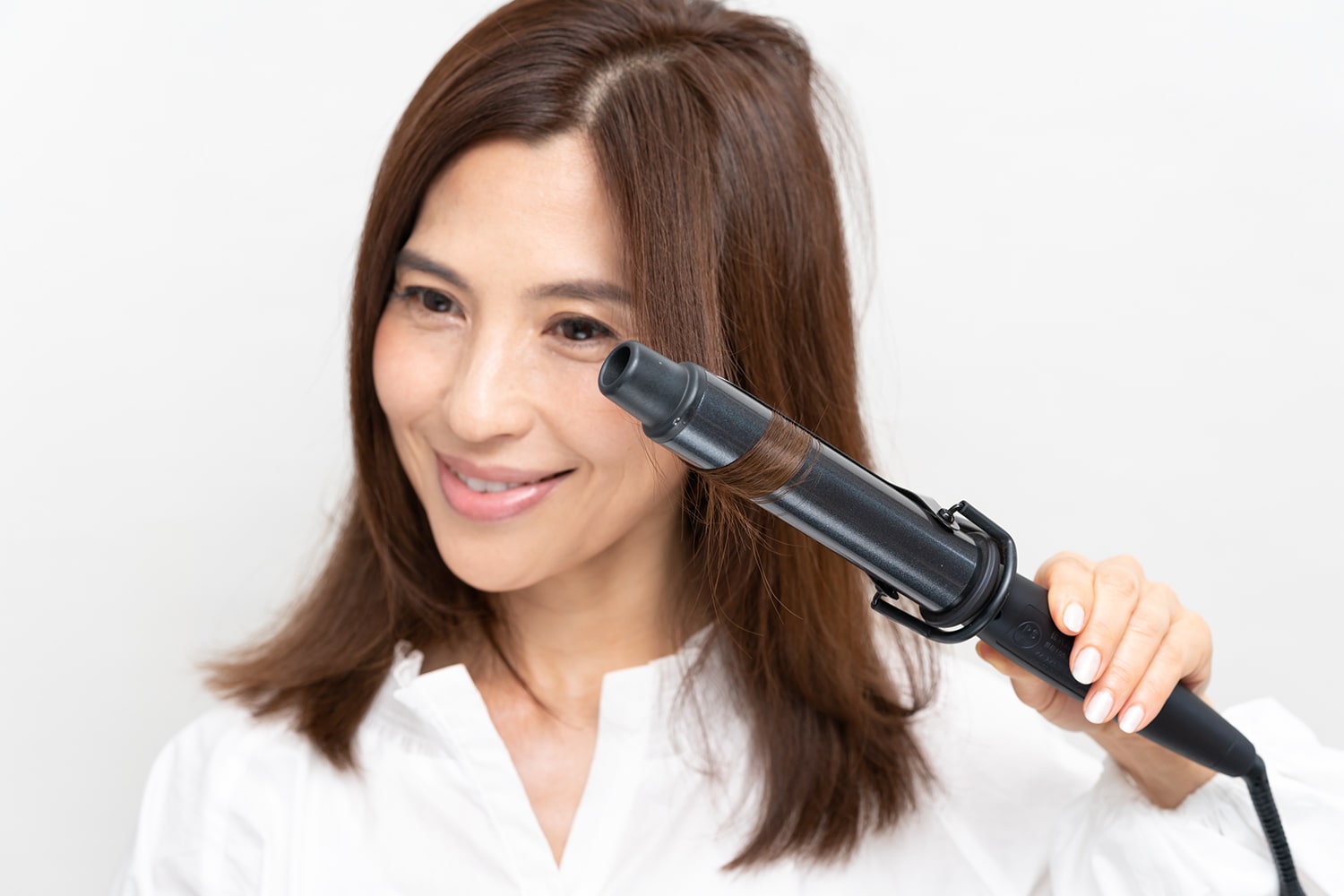 前髪部分だけ、毛束の中間からカールアイロンを通してから毛先を外巻きにする。