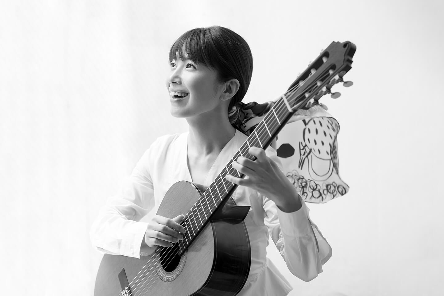 村治佳織さんの髪をふんわりと束ねるのはエルメス「カレ」の今年の春夏の柄、《おしゃべりな鳥たちの家》。村治さんが奏でるギターの音色とともに楽しげな鳥たちの歌声が聴こえてくるよう…。