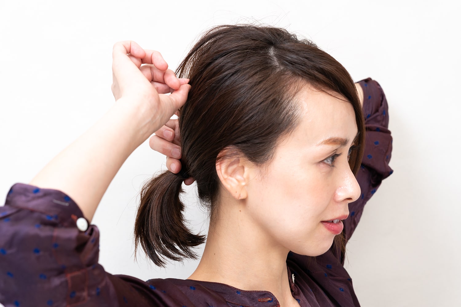 結び目を持ちながらハチ上の毛束をランダムに引き出す。爪で少量の髪をつまんで引き出すのがコツ。