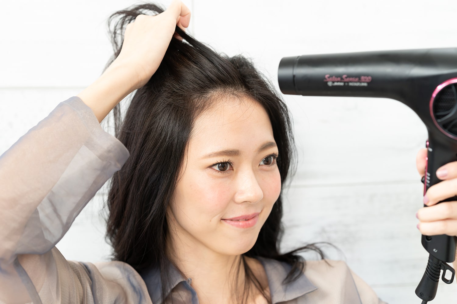 前髪とトップの髪の毛をかきあげたら、前方からドライヤーを当てる。根元を集中的に狙うと効果的。