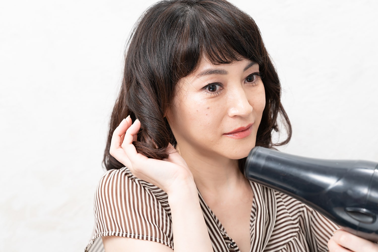 握ったまま毛先にドライヤーを当てる。