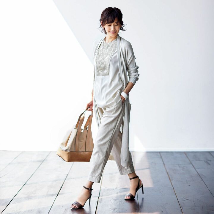 薄く軽く、爽やかなタッチの編み地。襟周りから前立てにかけてアイコンの「モニーレ」を配したロング丈に両サイドのポケットが大人かわいいアクセントを添えて。カーディガン￥197,000［コットン］・ブラウス￥287,000・パンツ￥164,000・バッグ￥240,000・靴￥105,000（ブルネロ クチネリ ジャパン）、ピアス￥290,000（カドー伊勢丹新宿店）、バングル￥12,000（チェルキ〈ギャレッタ〉）