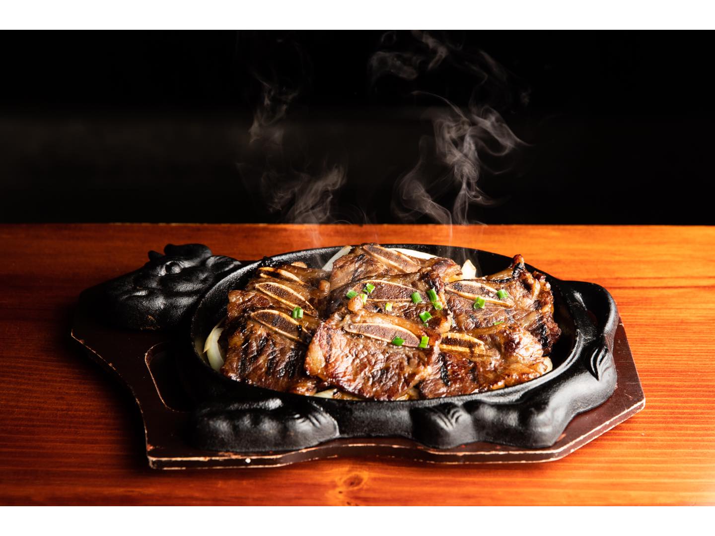 アツアツの鉄板で提供されて、甘めのつけだれが病みつきの味。骨付きL.A.カルビ¥1,800