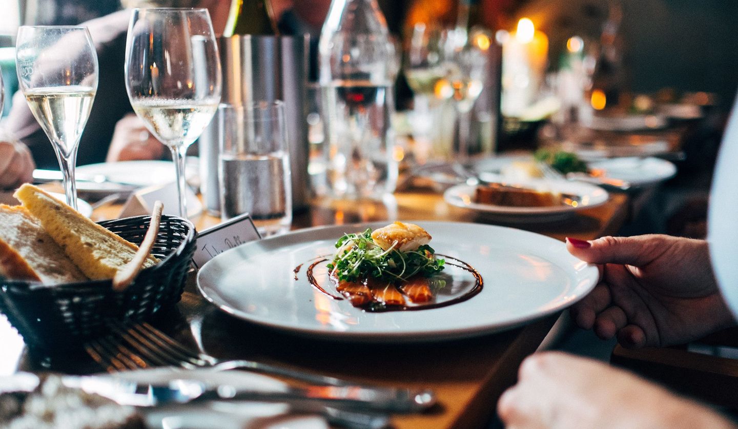 テーブルに料理とワインが並び、会食が催されている