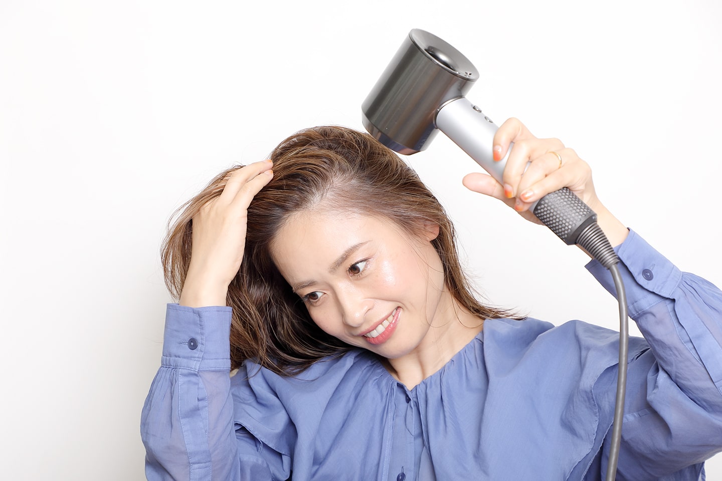 髪の根元を起こしながらドライヤーで乾かす。トップは左右両方向から風を当てて。