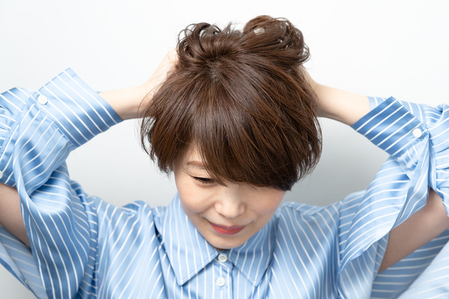 髪の内側から揉み込むようにワックスをなじませる。