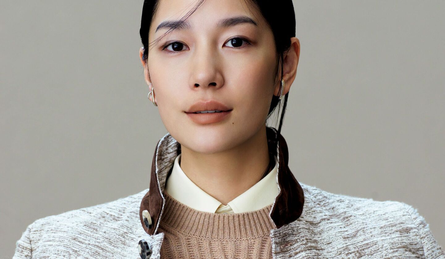 「ロロ・ピアーナ」のシャツにクルーネックニットを重ねて着用したモデル