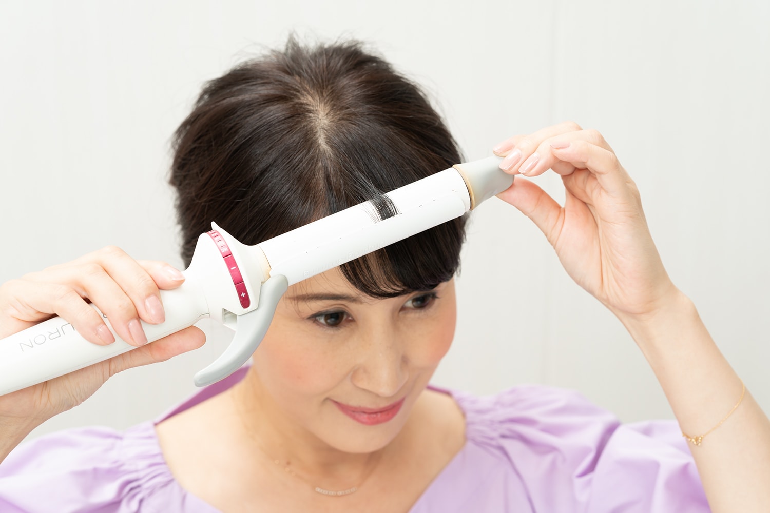 26mmを使用。前髪が割れないように細かく毛束を取ってワンカールする。