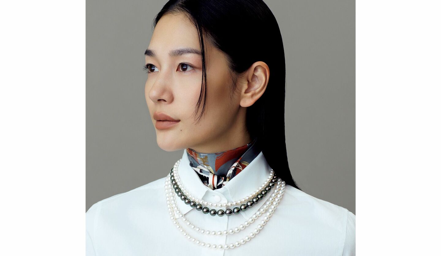 スカーフとパールネックレスをレイヤードしたモデルの大塚まゆかさん