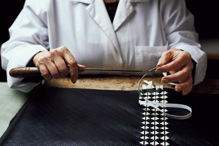熟練の職人が手作業で切り込みを入れたナッパレザーにリボンを編み込む｢モザイコ｣技法