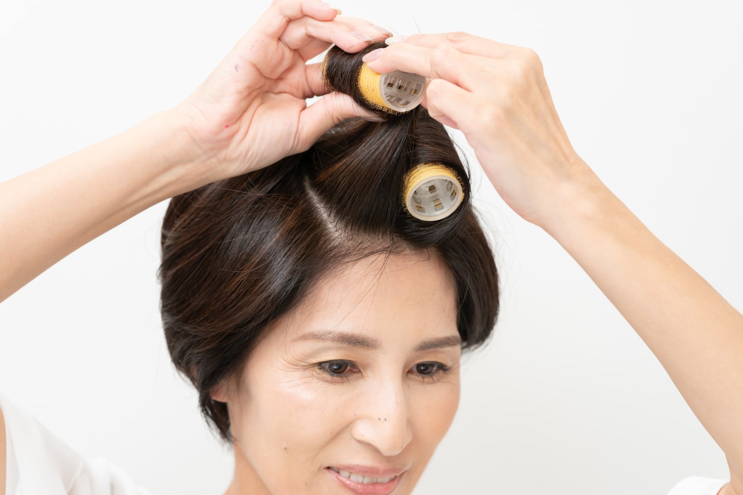分け目側に毛束を倒しながら、毛先から巻く。