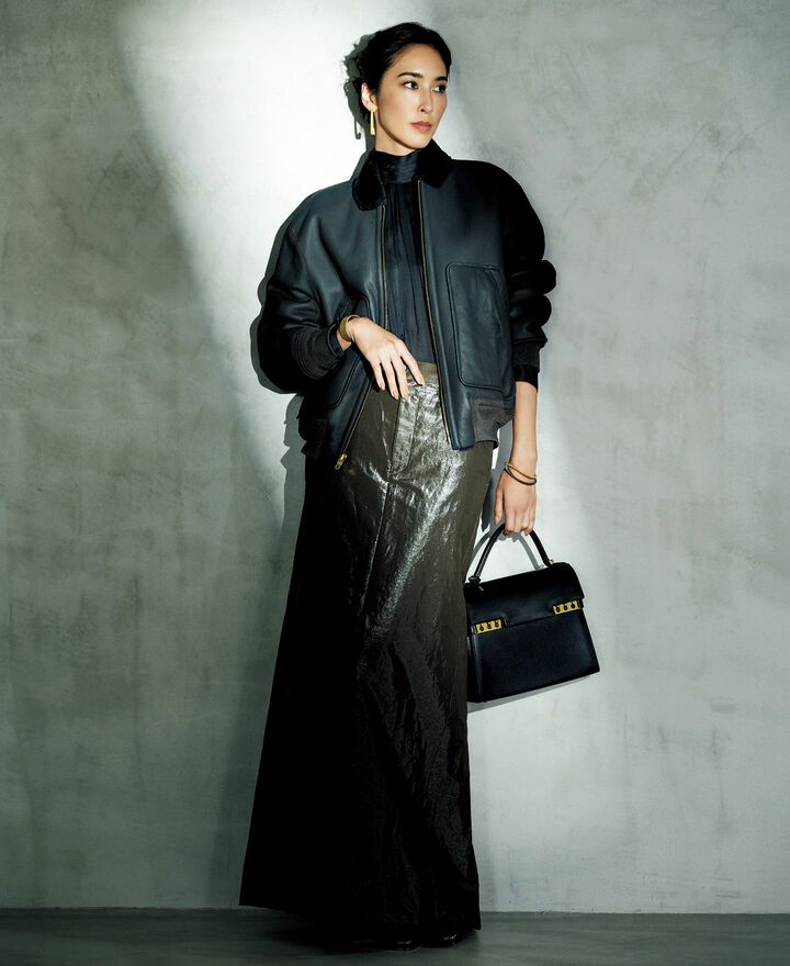 ムートンレザーのブルゾンにシャイニーツイルのマキシスカートを合わせたモデルの立野リカさん