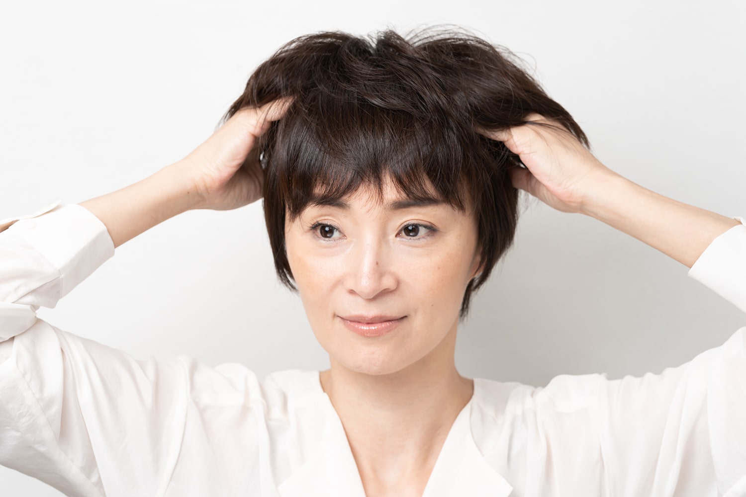 両手にワックスを広げたら髪をかき上げるようにワックスをなじませる。