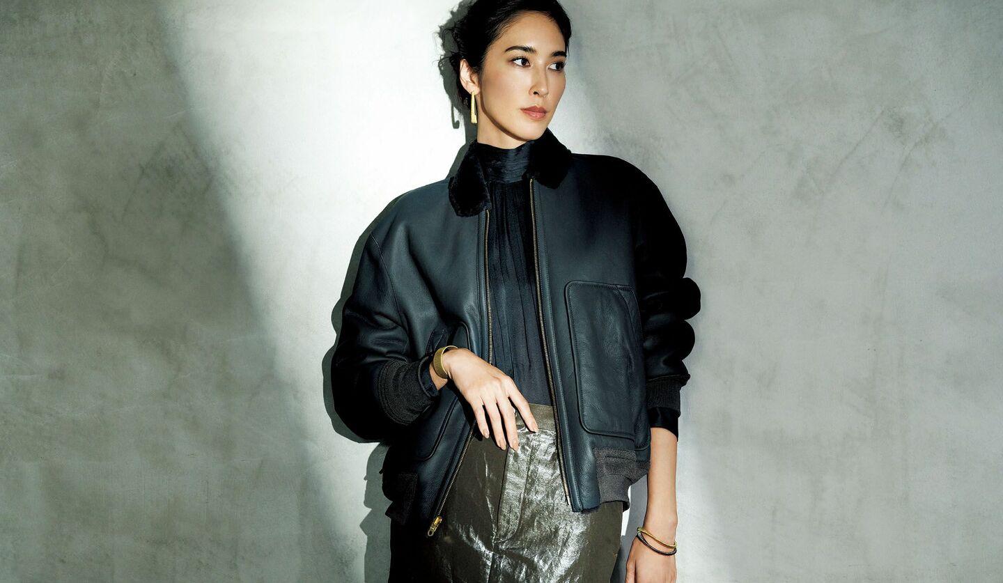 ムートンレザーのブルゾンにシャイニーツイルのマキシスカートを合わせたモデルの立野リカさん