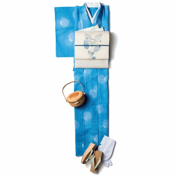 織りの白い帯で格上げした装い。綿麻の浴衣［仕立て上がり価格］¥100,000・正絹の名古屋帯¥150,000・帯揚げ¥12,000・帯締め¥15,000・桐の草履¥15,000・ナンタケットバスケット¥230,000・麻の半襟¥9,000（田園調布 秀や）、帯留め¥17,000（伝統工芸 青山スクエア）、足袋¥2,600（GINZA 和貴）