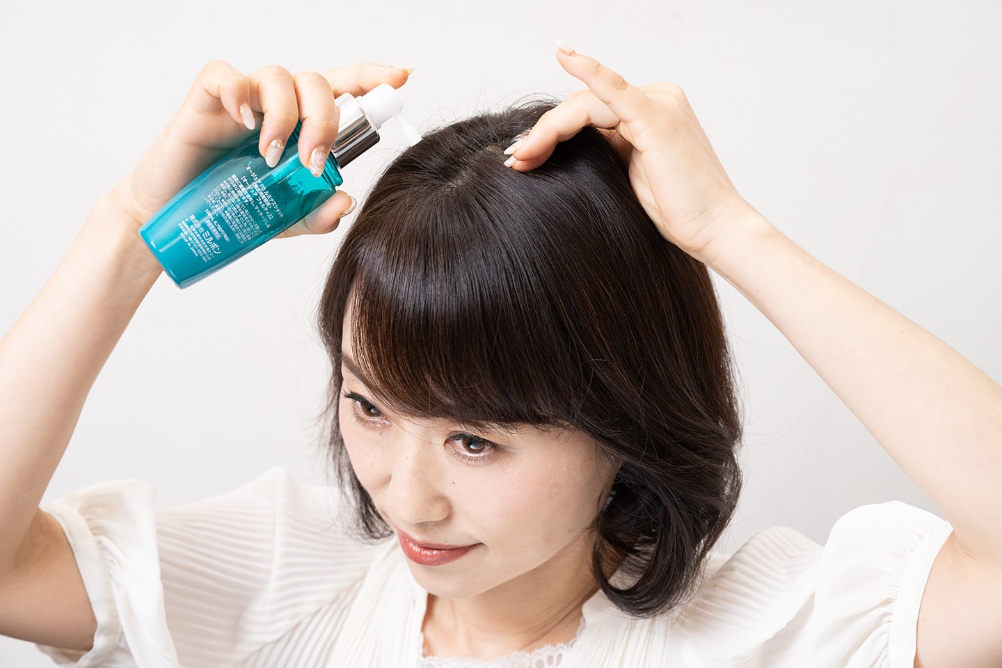 美容液を頭皮に噴霧して、指の腹で揉み込む。