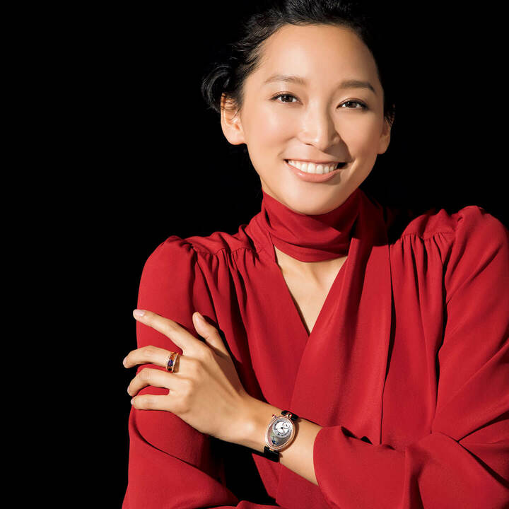 ムーンフェイズとパワーリザーブ、スモールセコンド、オフセンターダイヤルを、128個のダイヤモンドをセットしたベゼルが囲んで。『クイーン・オブ・ネイプルズ 8908』￥3,910,000［ローズゴールド×ダイヤモンド ケースサイズ縦36.5×横28.45㎜ サテンストラップ 自動巻き］・リング『ミニ・クイーン』￥660,000［ローズゴールド×アメシスト×ダイヤモンド］（ブレゲ ブティック銀座） ブラウス￥80,000（サン・フレール〈レ・コパン〉）　