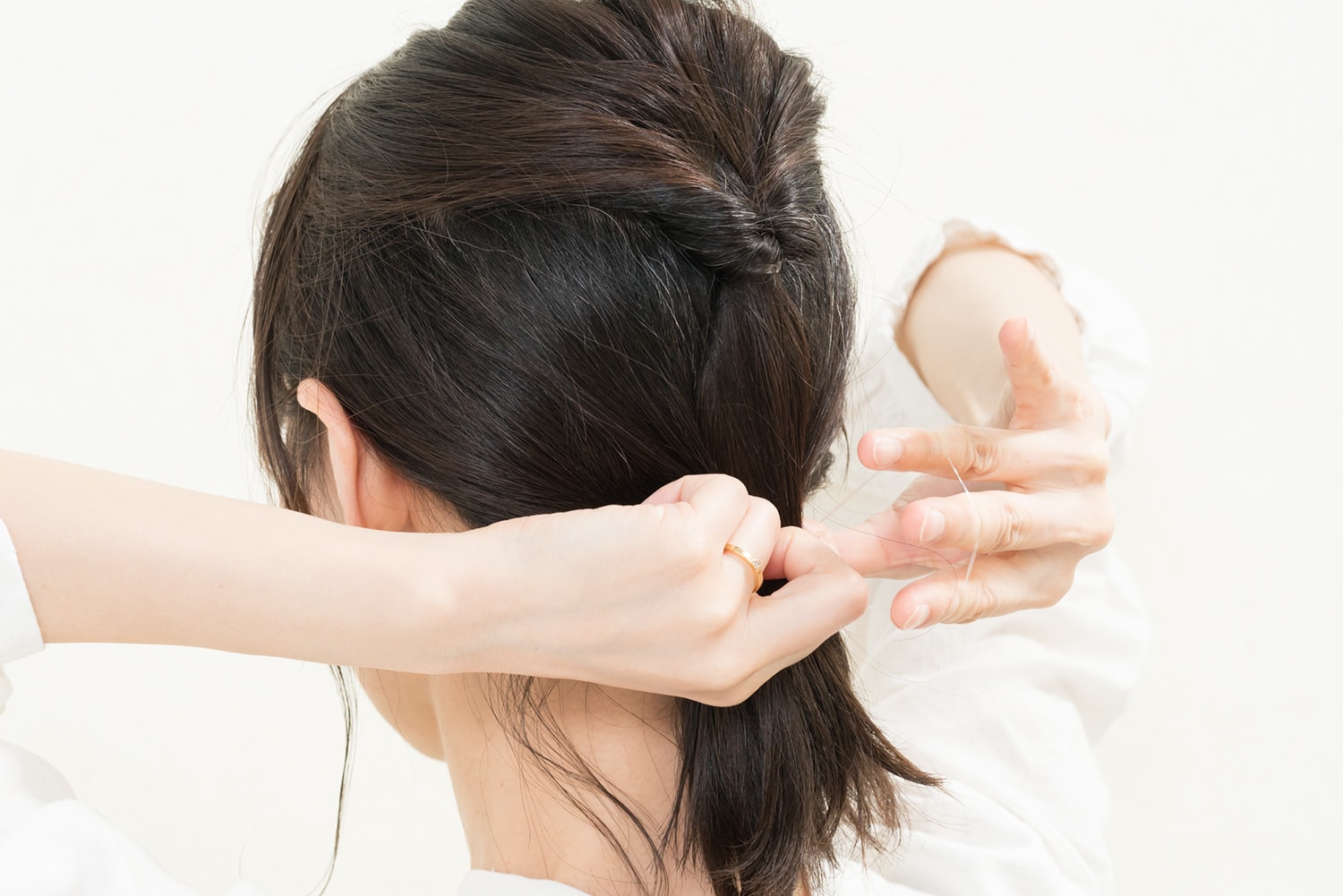 このときに、うなじの後れ毛は結ばずに残して結ぶ。指でひとつまみほどの毛束を残して。