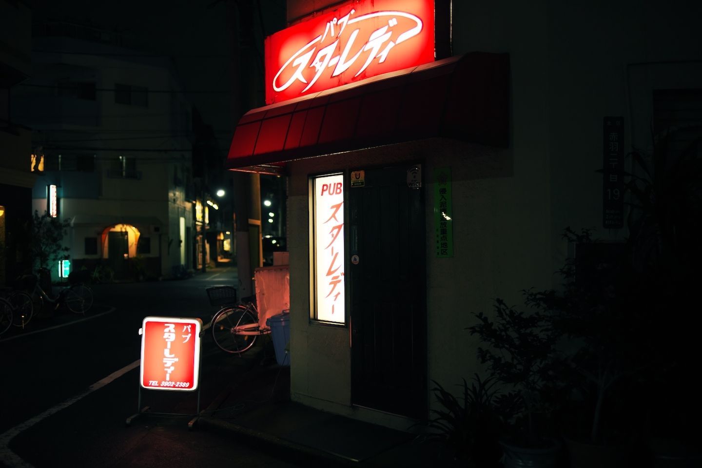 暗闇の中で、昭和の雰囲気が漂う赤いサインが目立つ