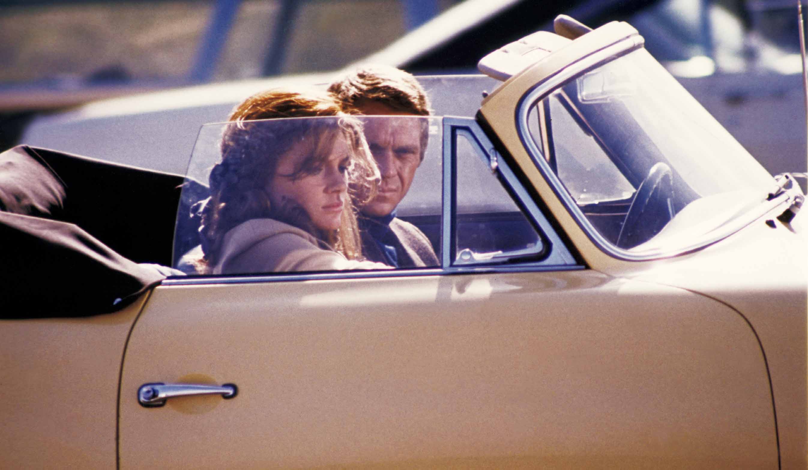 マックイーン演じるブリットが恋人キャシー(ジャクリーン・ビセット)の運転するポルシェ『356カブリオレ』で語り合う。アメリカンマッスルカーが登場するアクションシーンと対照的な、穏やかで絵になるシーンだ。©Getty Images