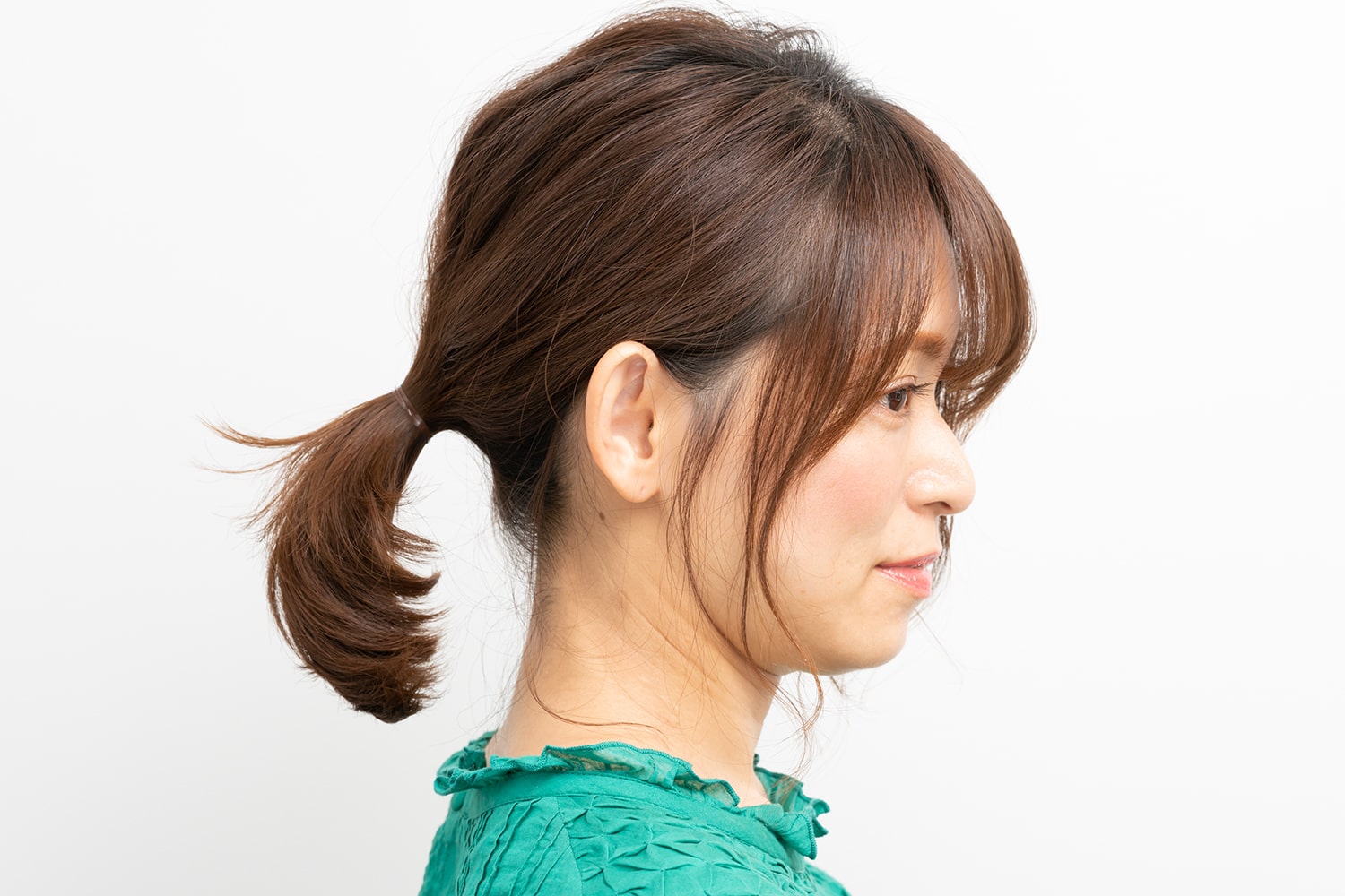 もみあげ、耳の後ろのひとつまみ分の毛束を残して髪を束ねる。