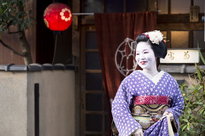 祗園東の置屋「富菊」前で微笑む富津愈さん