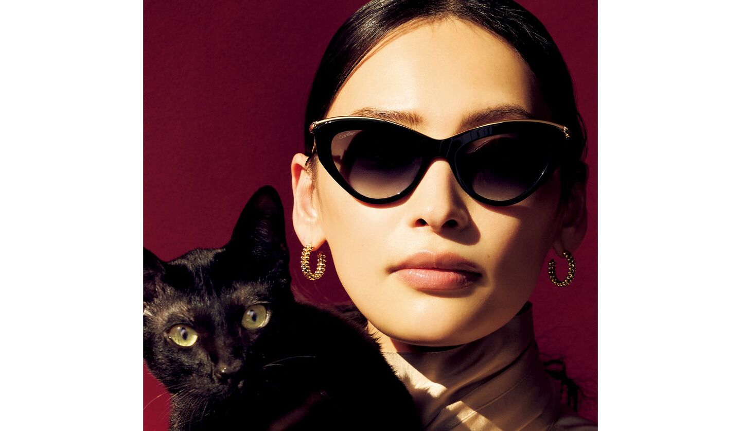 「カルティエ」のサングラスを着用したモデルの大政 絢さんと猫