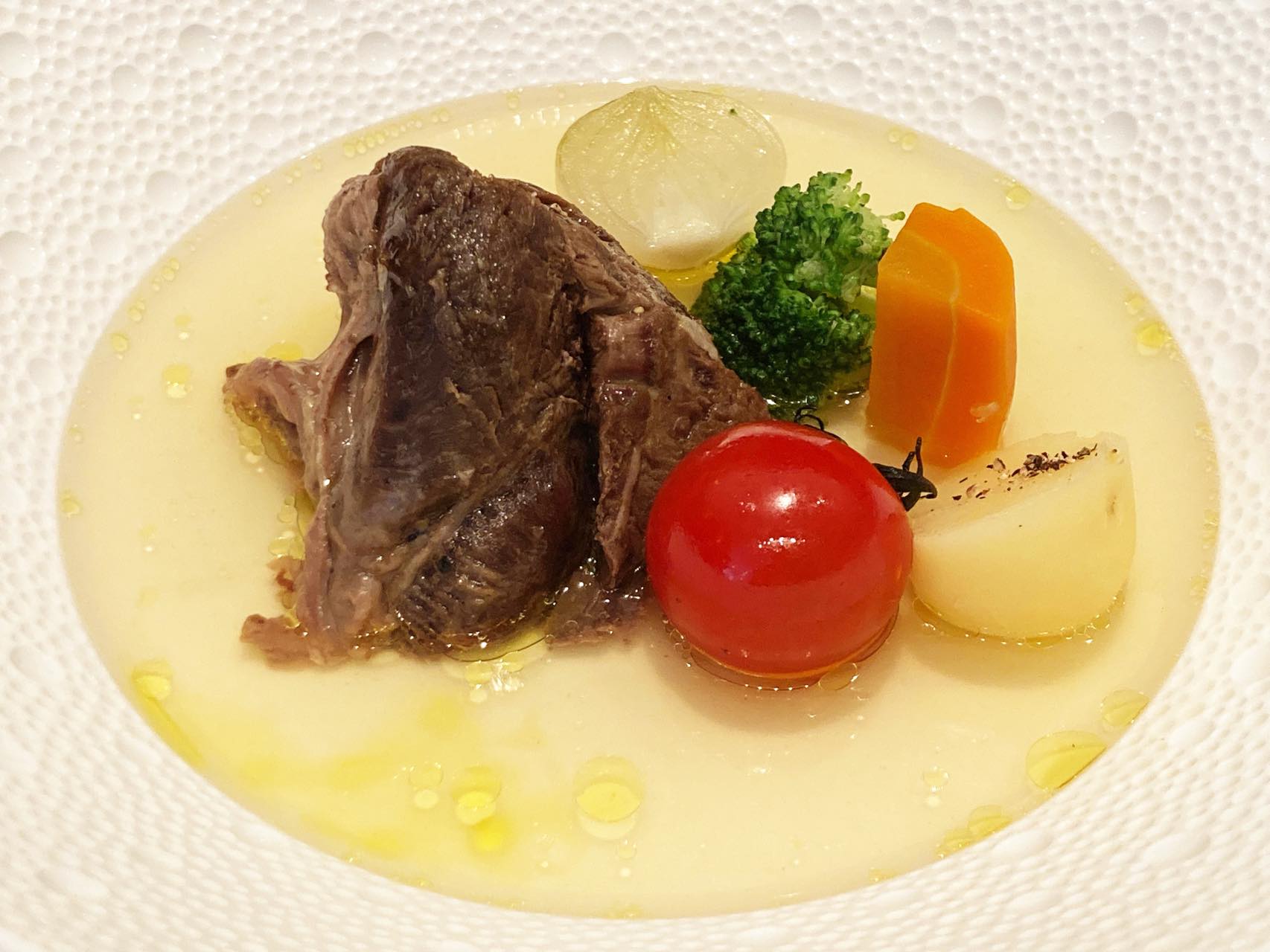 イタリアの伝統的煮込み料理「ボッリート」が華麗に上品に変身して登場。ほろほろになるまで煮込まれた牛スネ肉をあじわいつつ、極上のコンソメを味わうという無限連鎖。