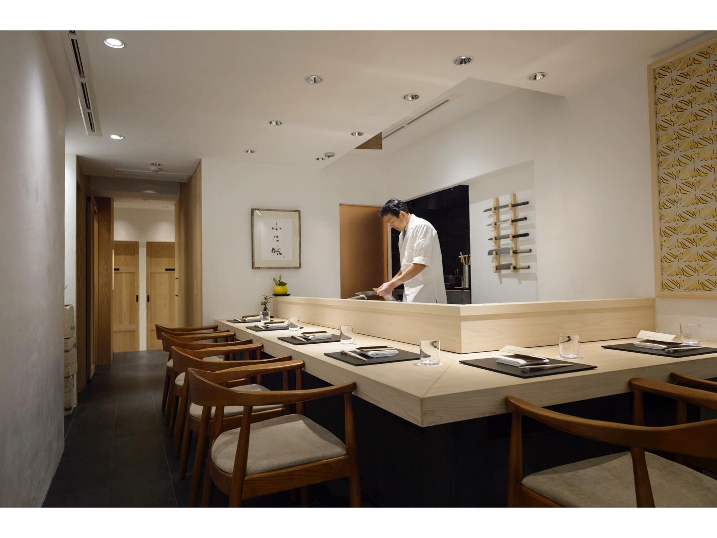 西山さんの故郷、愛媛県の檜を使ったカウンターが目を引く店内。右側に飾られた作品は愛媛県・五十崎の和紙産業の活性化を目指す気鋭の手工業所「五十崎社中」によるもの。凛とした清潔感と温かみが共存する空間です。