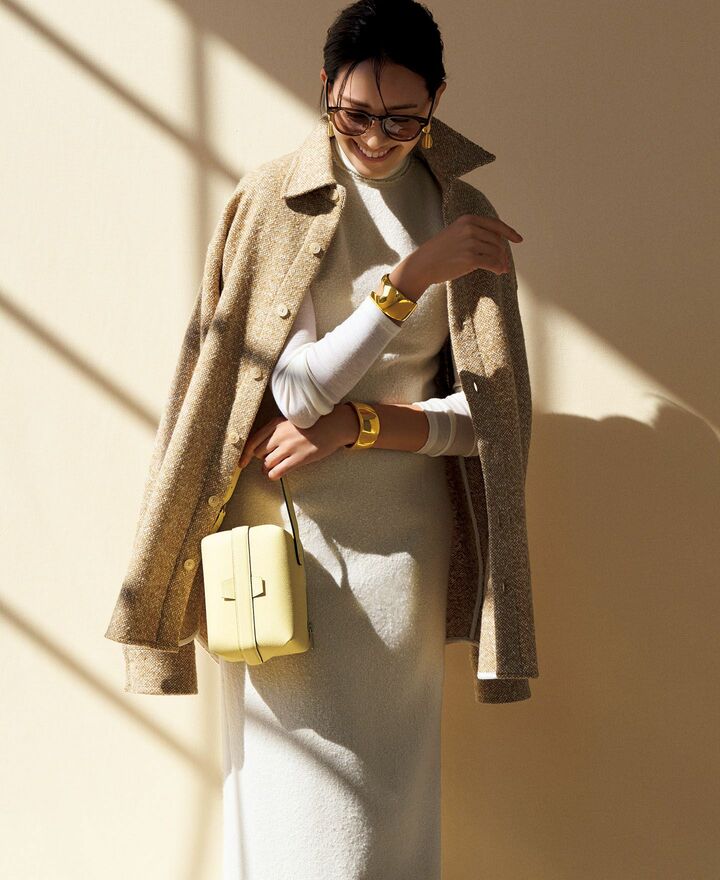 オフ白のニットとノースリーブドレスのコーデ