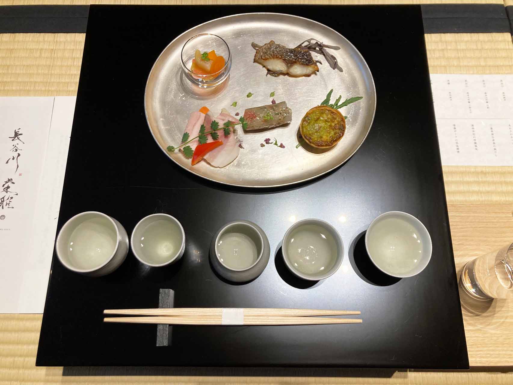 和室に上がるとこのようなセッティングが用意されていた。日本酒は左から順番に、料理は手前中央のがすえびから時計回りにいただくシステム。